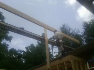 Carpenter setting a ridge beam over a new addition frame — Ice Dam Removal by Roofing Brothers in Roundhill