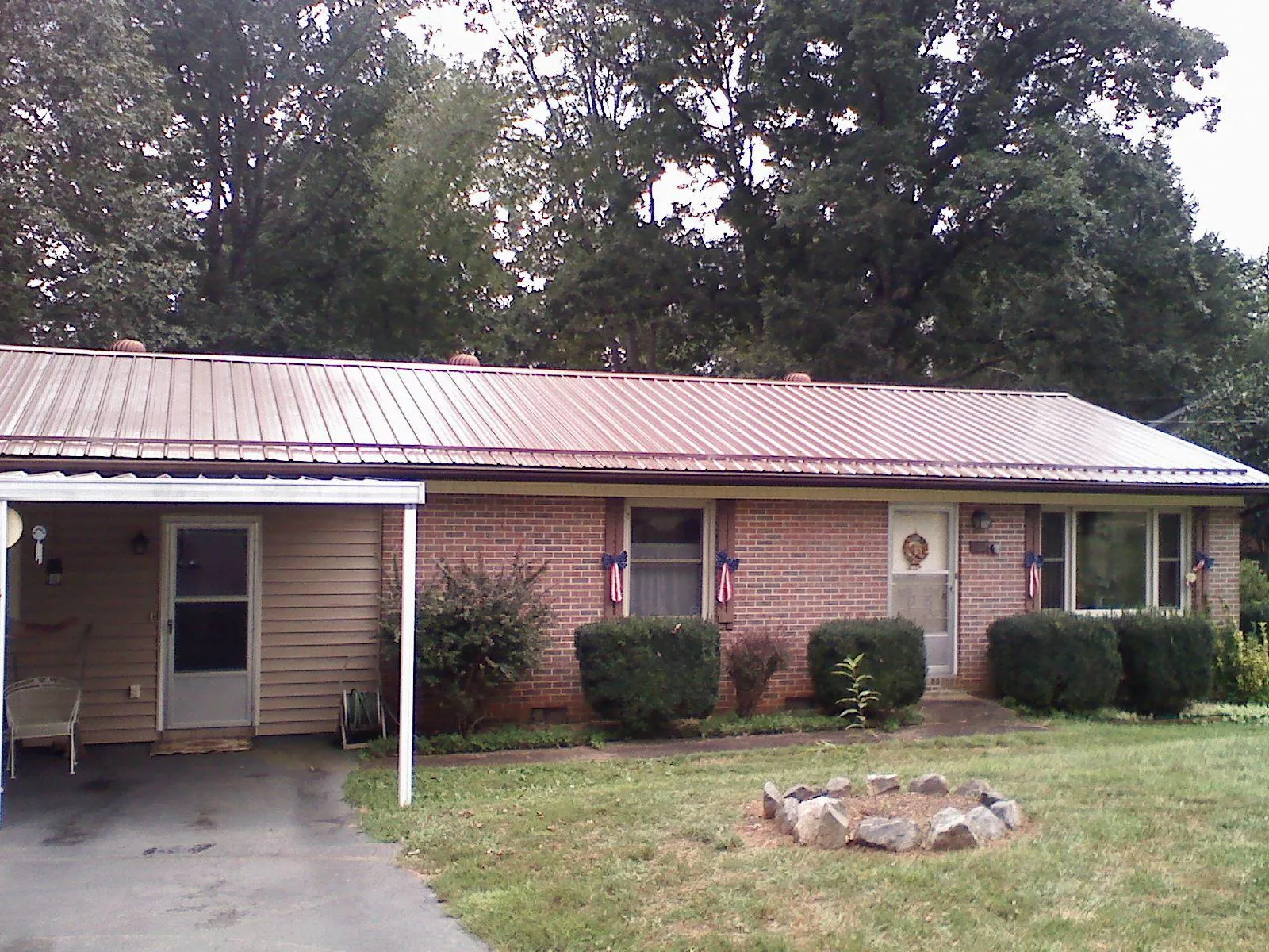 Bronze metal roof and carport on a brick ranch home — Roof Repair work by our crew in Roundhill